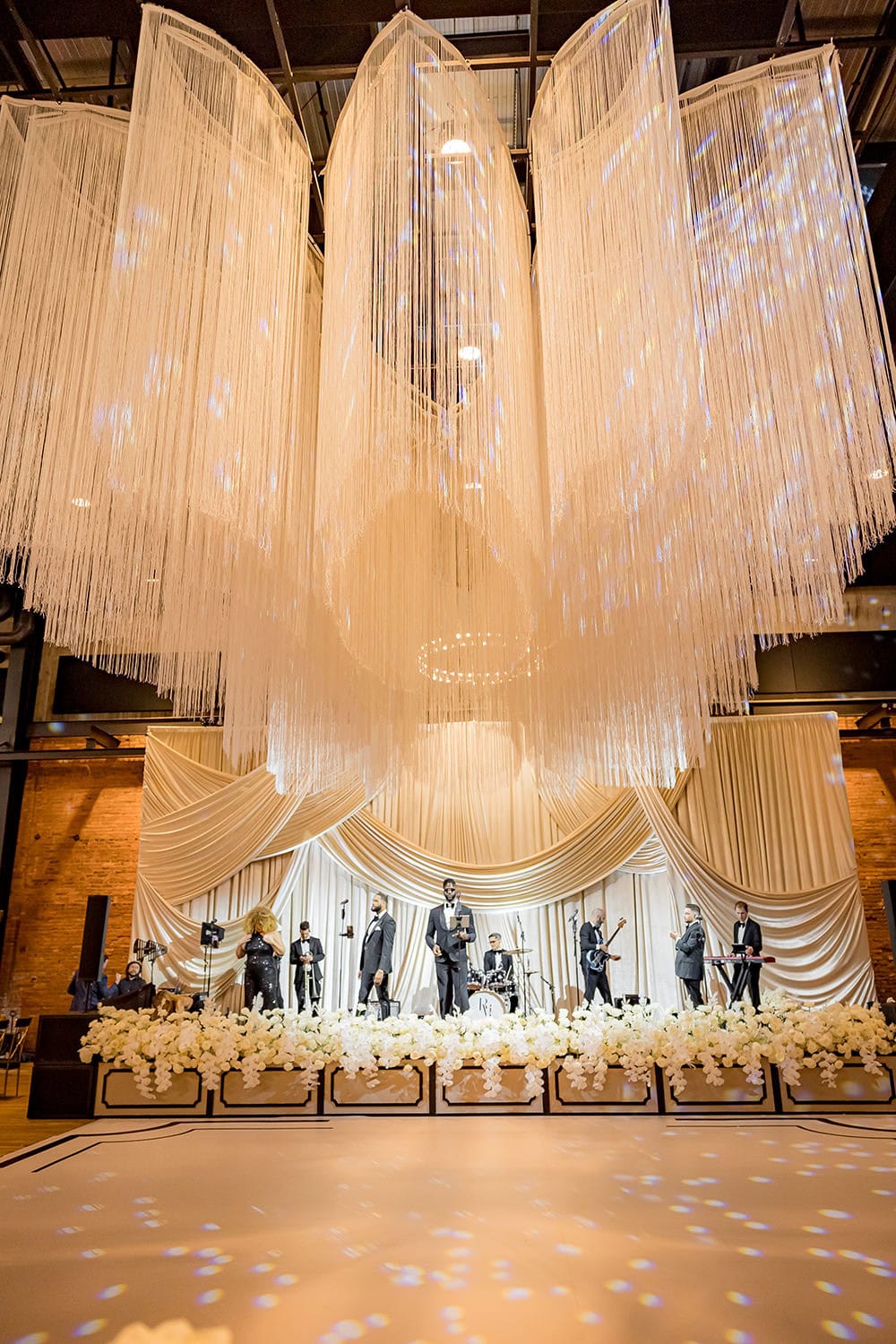 Stunning wedding stage with draped curtains, floral arrangements, and elegant lighting at a Colorado.