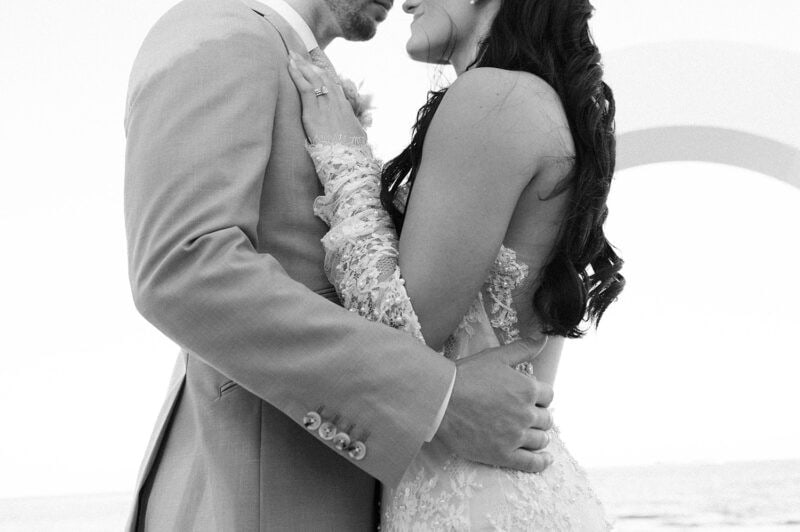 Elegant wedding couple embracing outdoors.