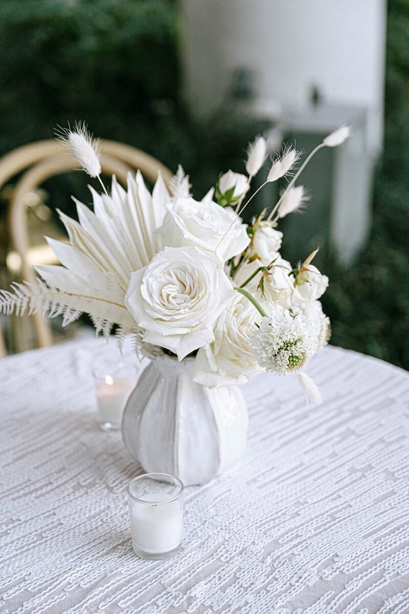 Beautiful white floral arrangement with roses and pampas grass for wedding decor.