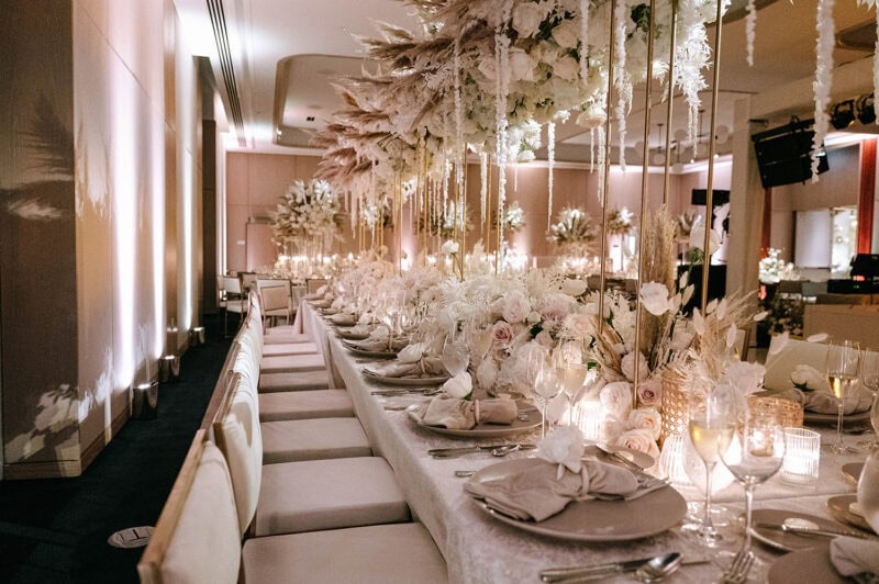 Beautifully decorated wedding reception table with floral arrangements and elegant tableware.