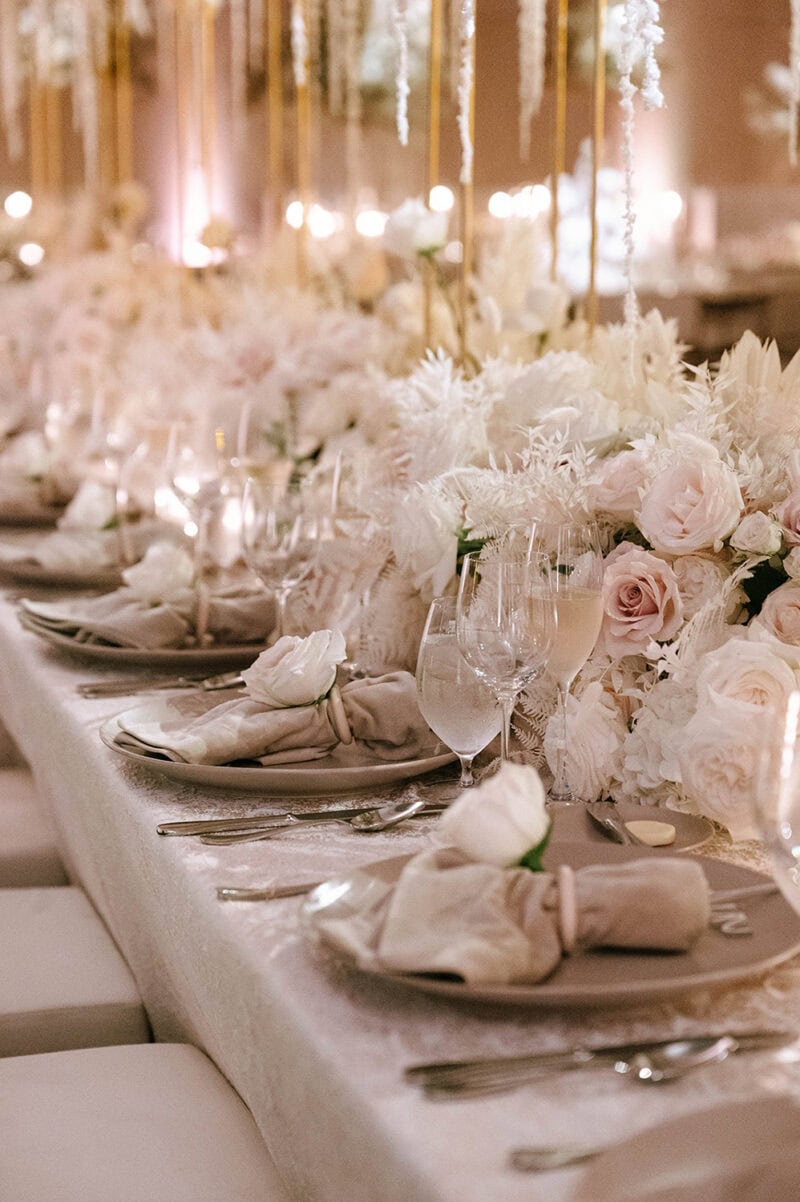 Elegant wedding table with floral arrangements and sophisticated place settings.
