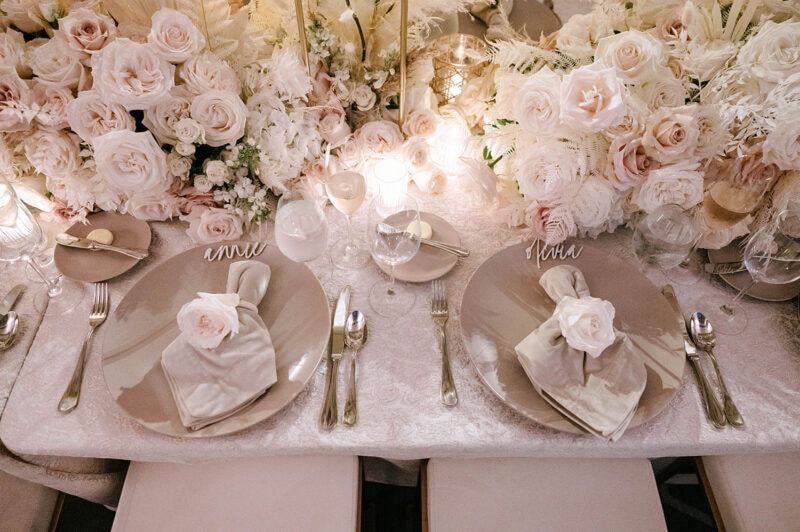 Beautiful wedding table setup with roses, candles, and sophisticated place settings.