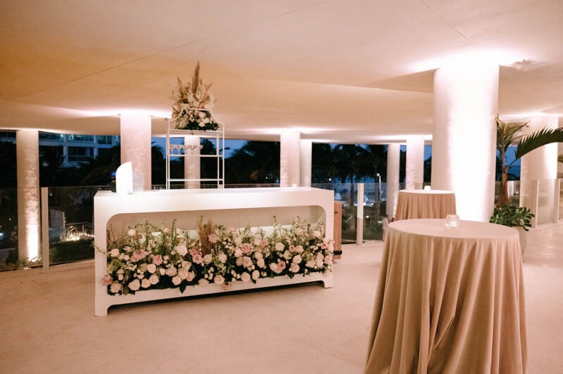 Elegant floral arrangement with soft pink and white flowers at a wedding reception.