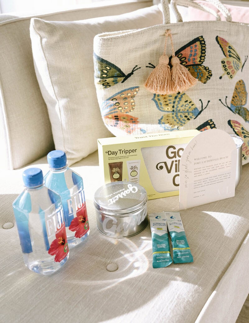 Wedding favor display with water bottles, candles, and a butterfly-themed bag.