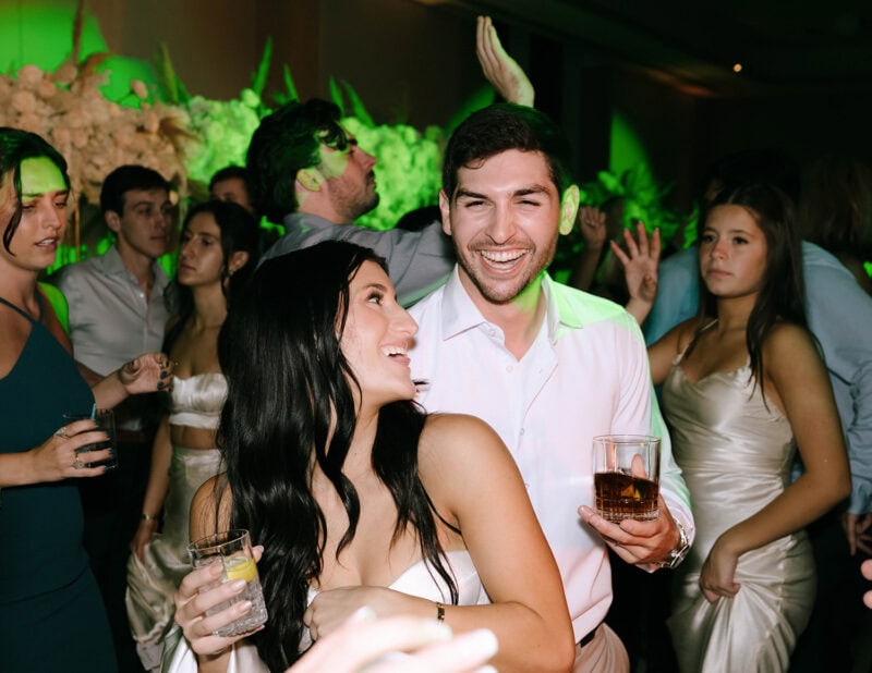Celebrating a wedding with happy guests enjoying music and drinks at an elegant event.