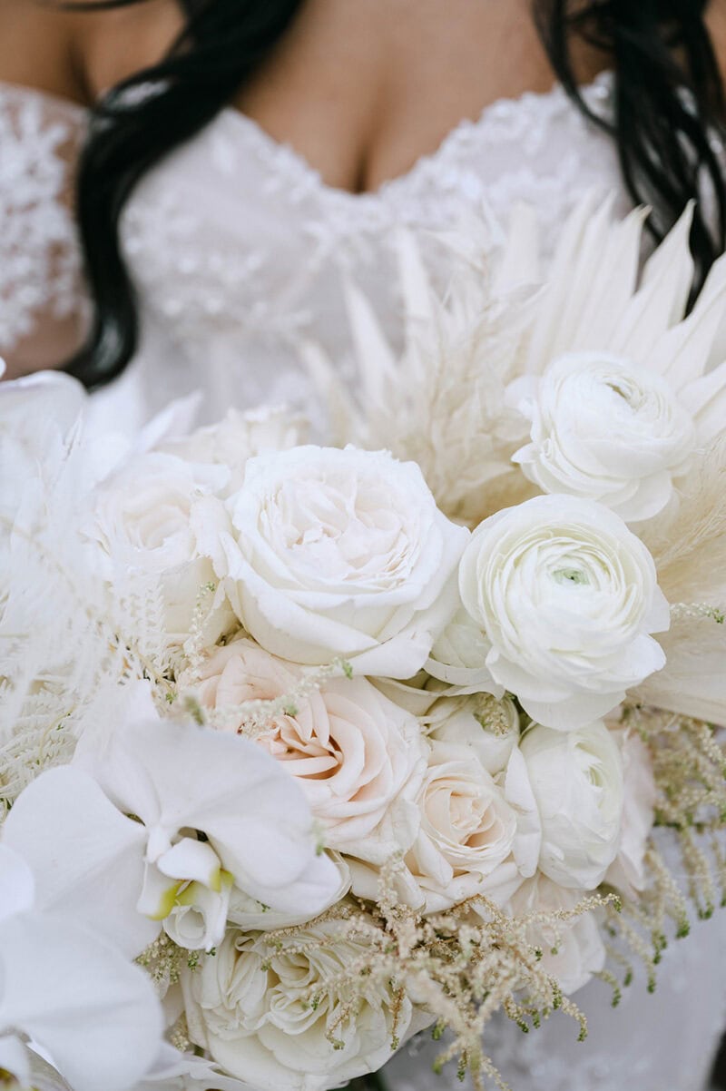 Bridal bouquet featuring white roses, peonies, and lush greenery for a wedding.