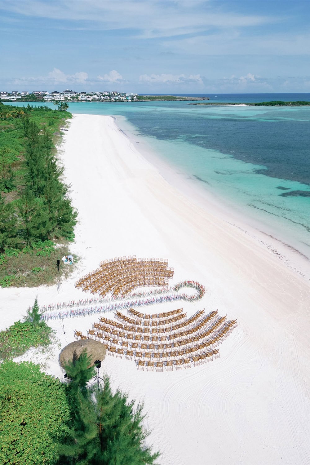 Beach wedding setup with ocean view and decorative seating arrangements.