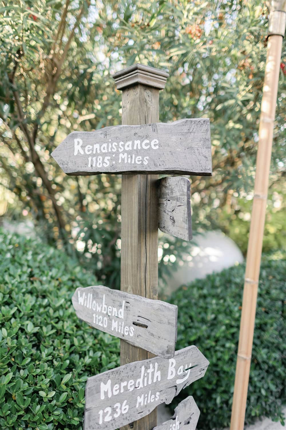Rustic wooden signposts showing distances to Renaissance, Willowbend, and Meredith Bay.