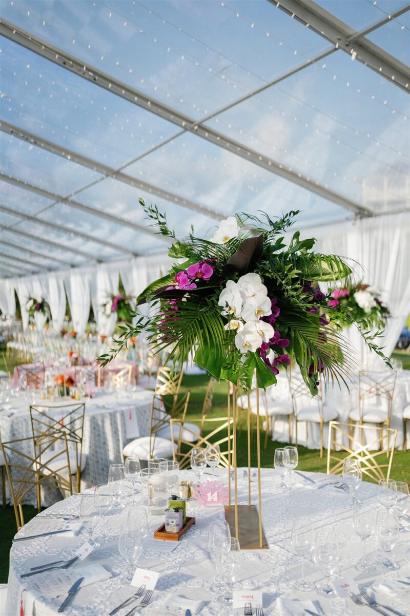 Beautiful floral arrangement with orchids and greenery at a wedding reception.