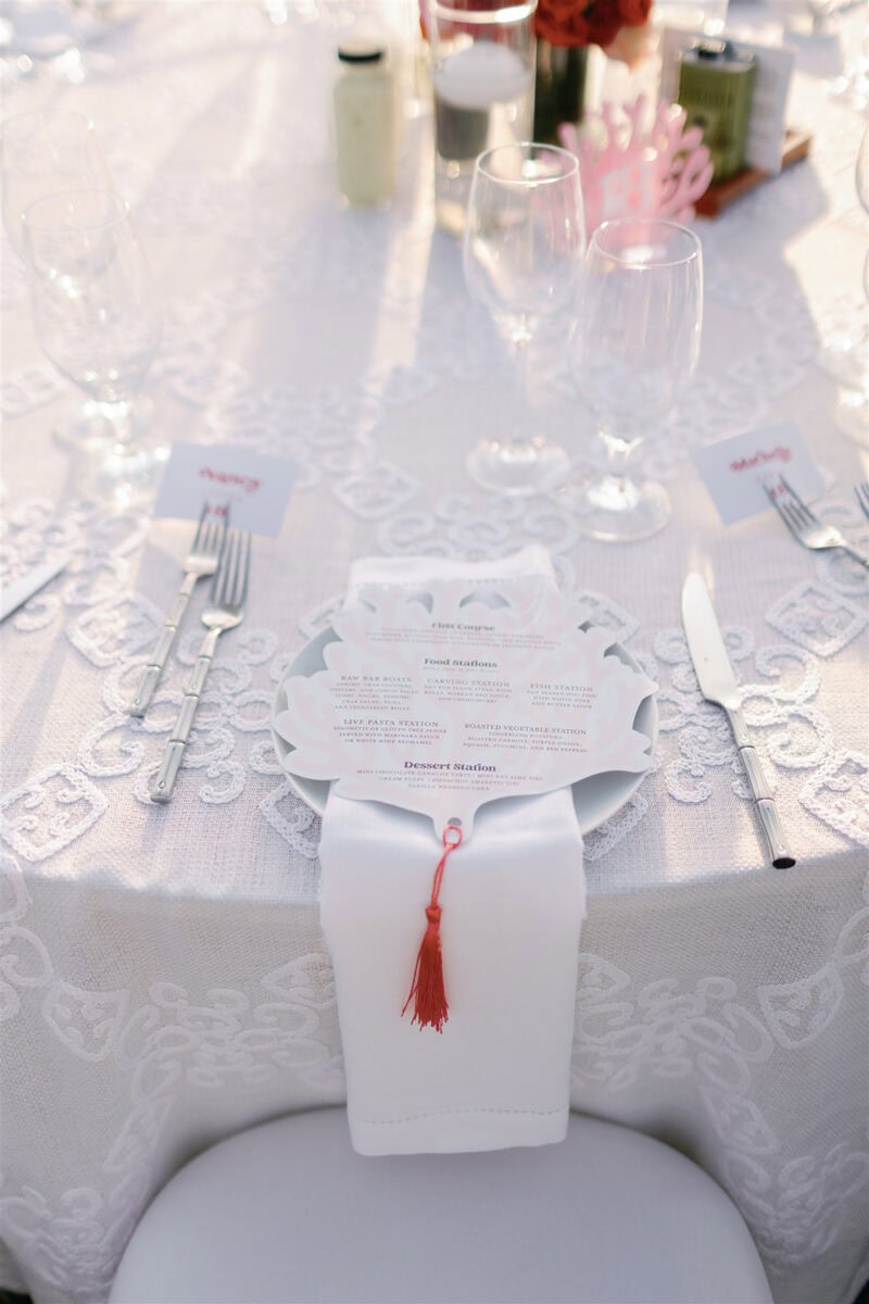 Wedding table with personalized menu, glassware, and floral centerpiece.