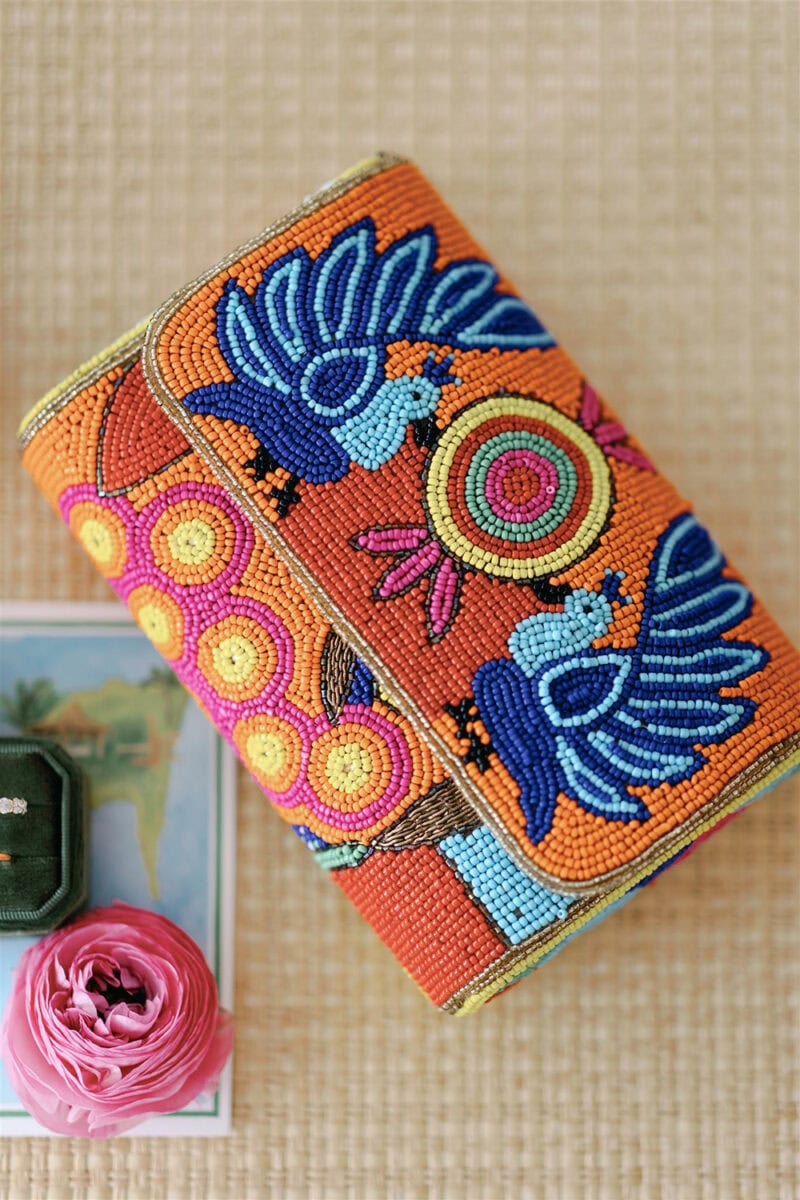 Beaded clutch featuring vibrant blue birds and colorful patterns, perfect for a wedding accessory.
