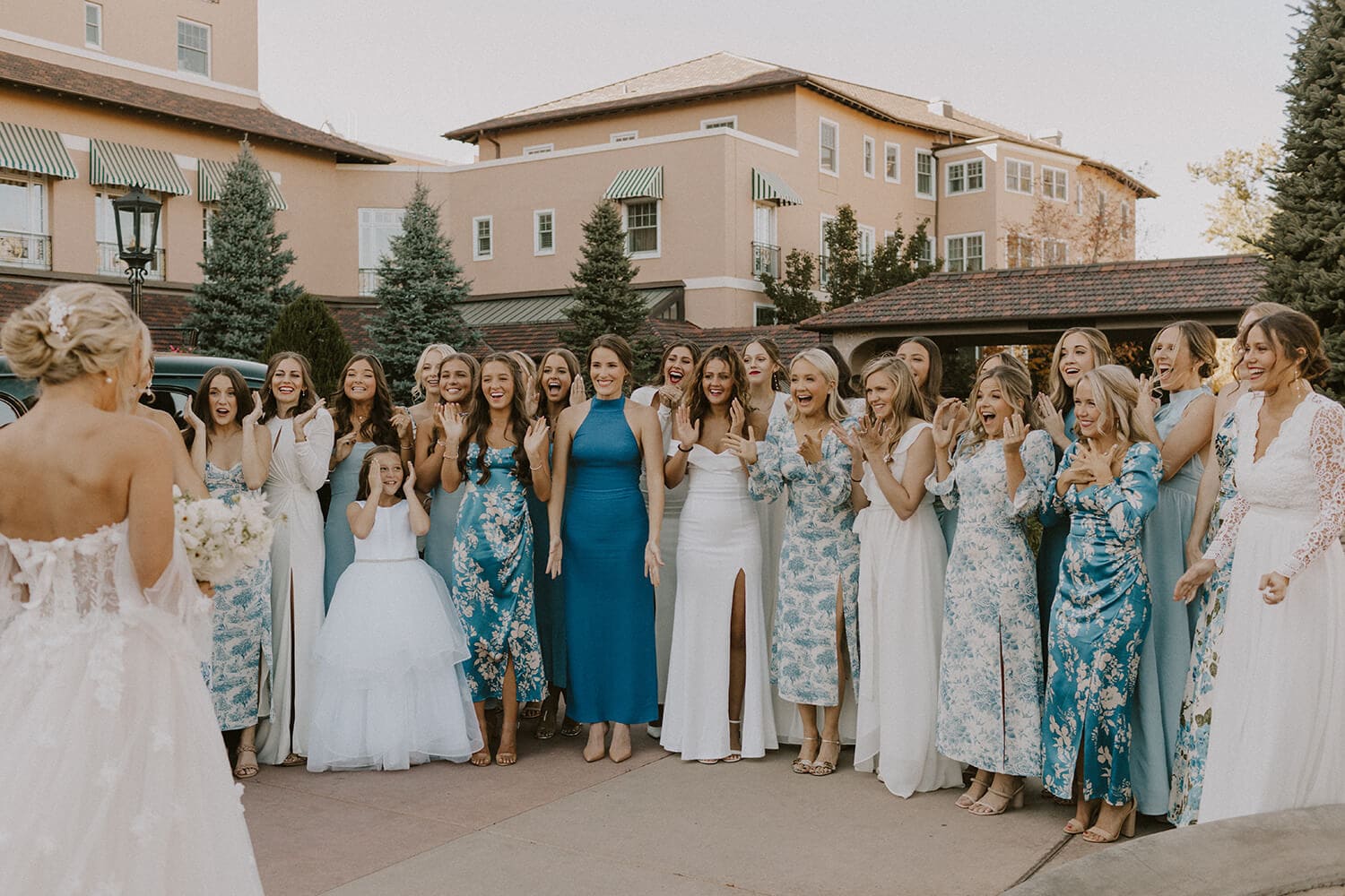 Bridesmaids and flower girl gather for a wedding photo outdoors in Colorado.