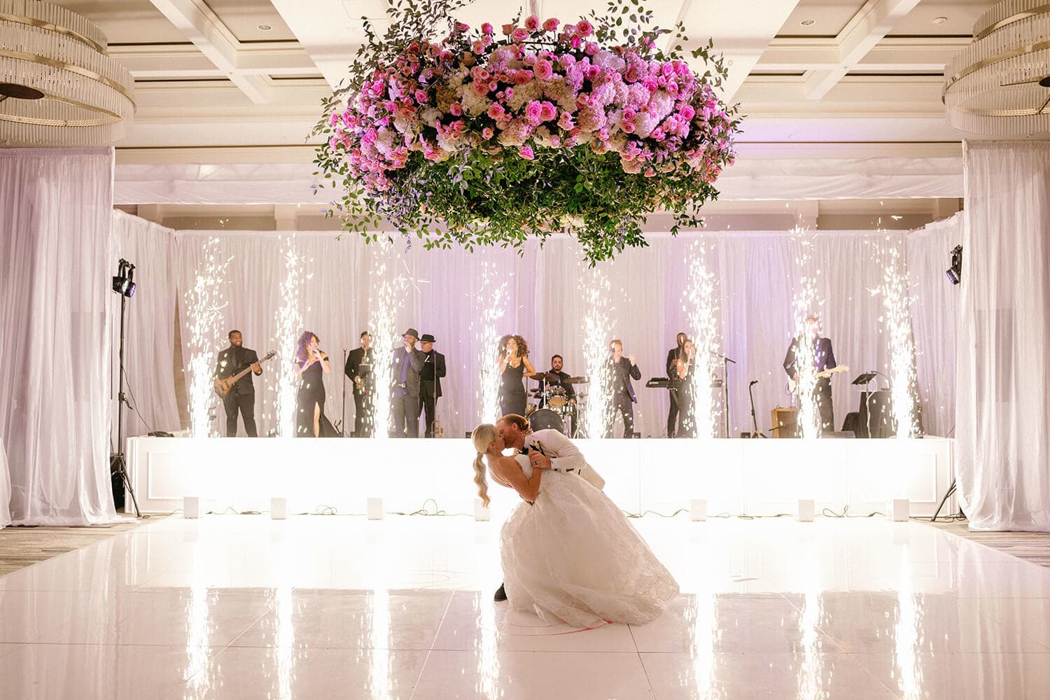 Wedding couple dancing on the dance floor with a live band playing in the background.