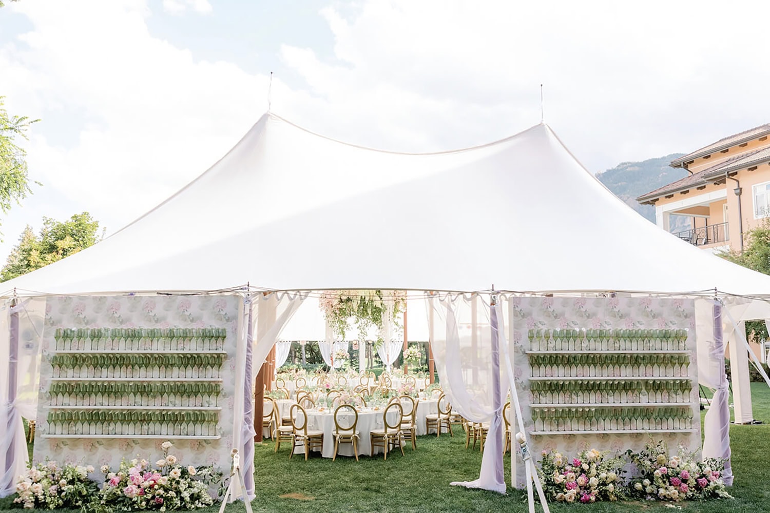 Beautiful white wedding tent with floral decor and seating arrangement.