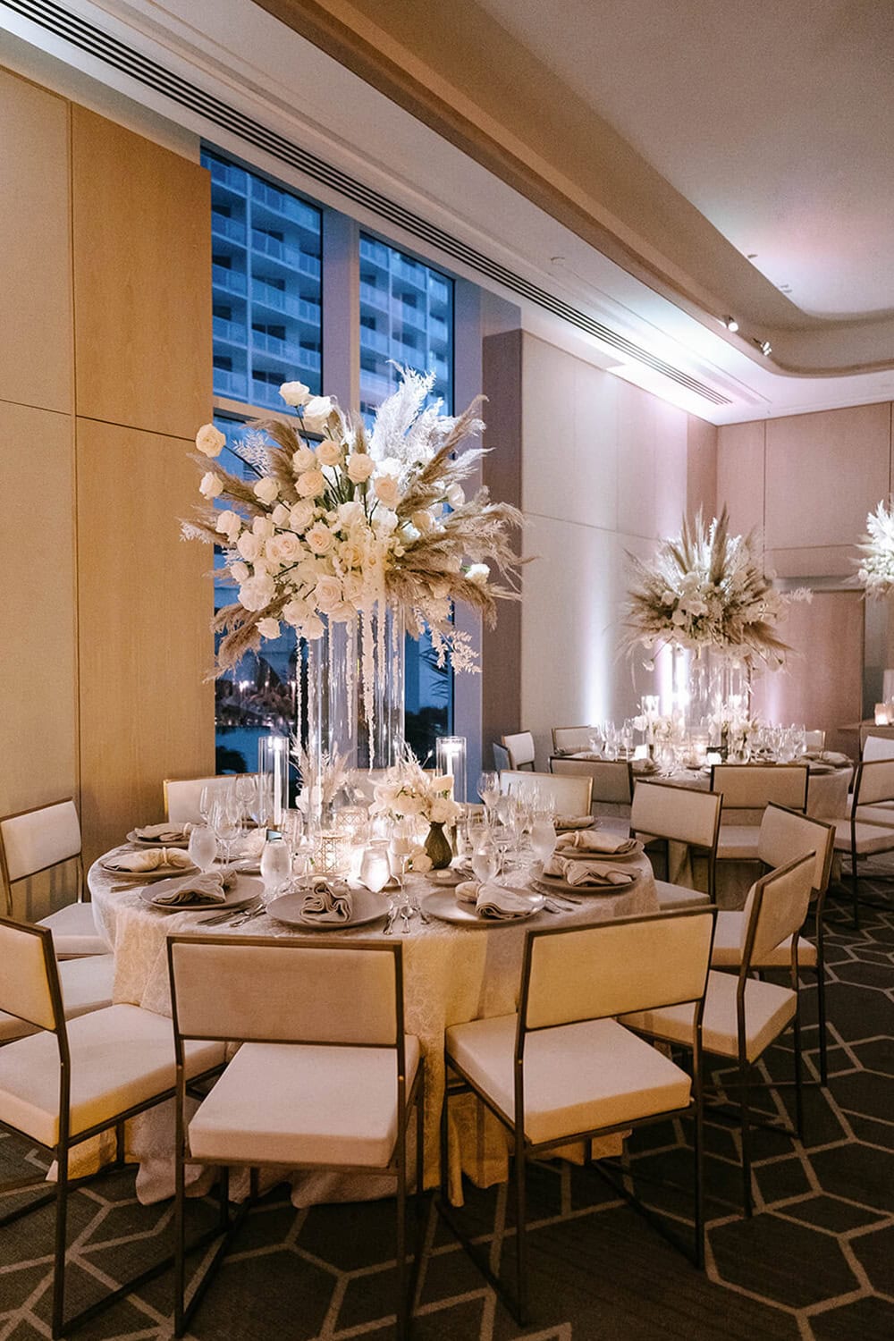 Elegant wedding reception table with floral centerpieces and ambient lighting.