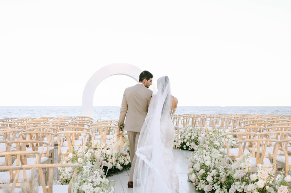 Bride and groom walking down the aisle at an outdoor wedding ceremony.