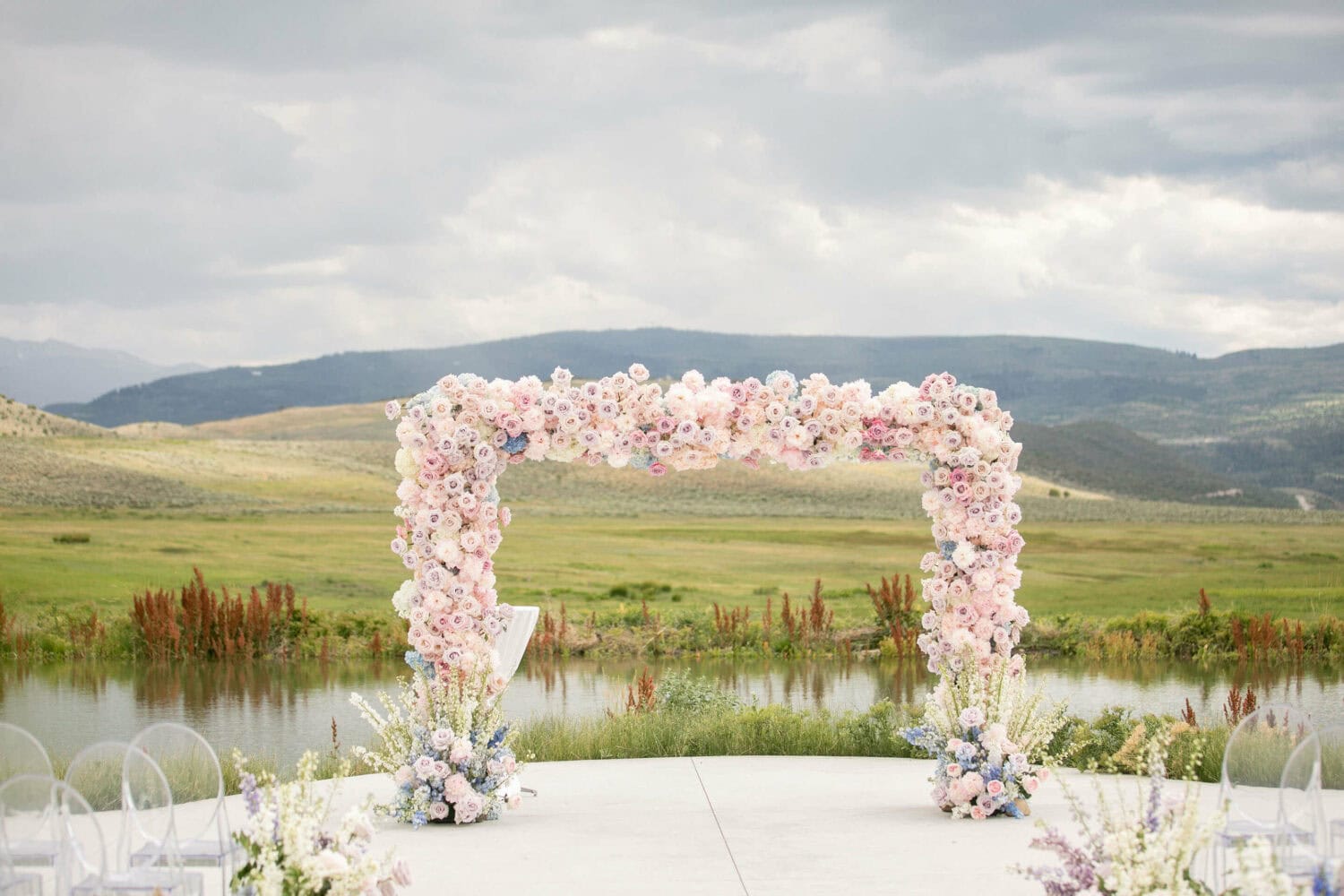 Floral arch decorated with pink and white flowers for outdoor wedding ceremonies.