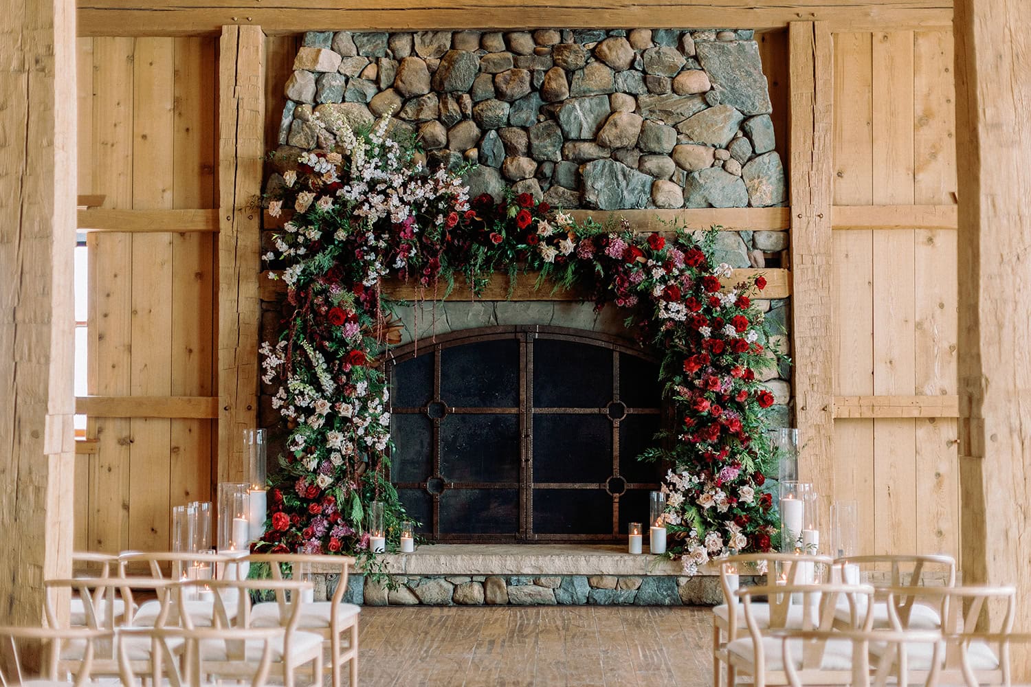 Elegant fireplace with floral arch for wedding ceremony.