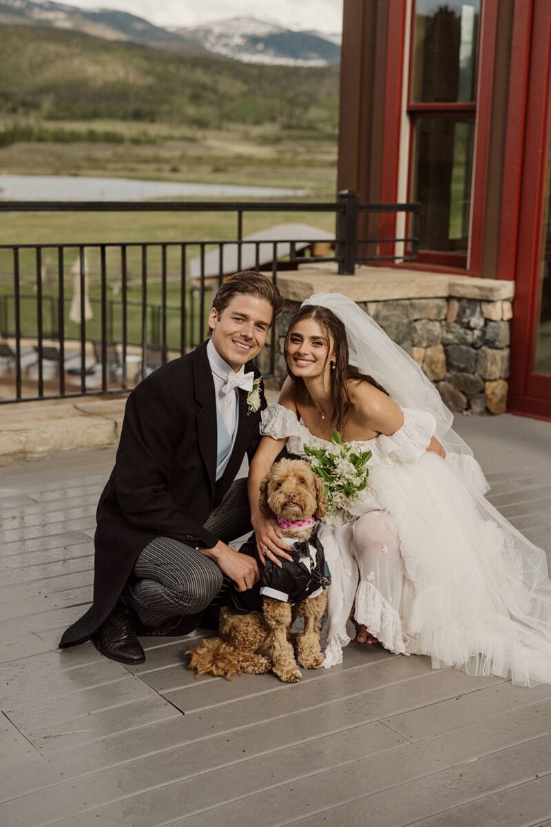 Bride and groom with their dog during wedding celebration.