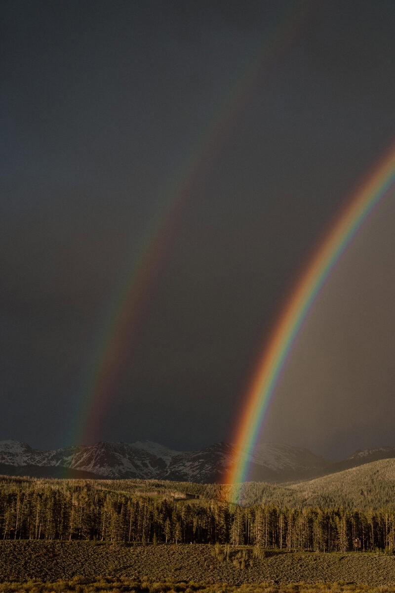Rainbow over mountain landscape during cloudy weather.