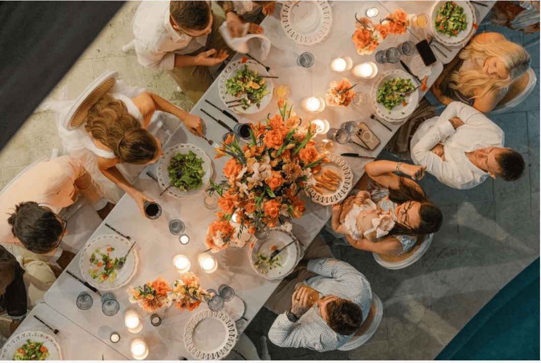 Guests enjoying a beautifully decorated wedding dinner with floral centerpieces.